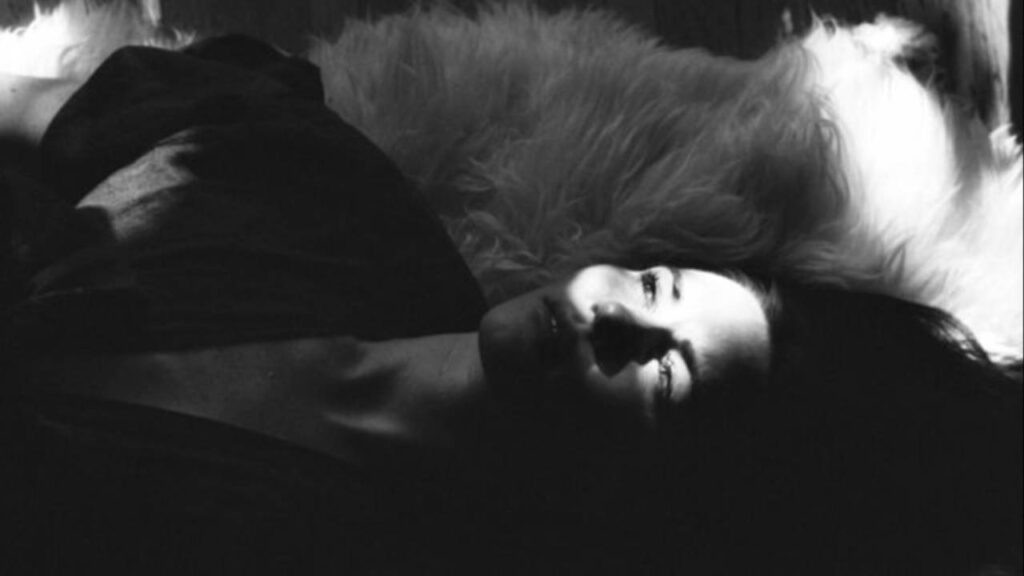Black and white image of woman laying down, looking up
