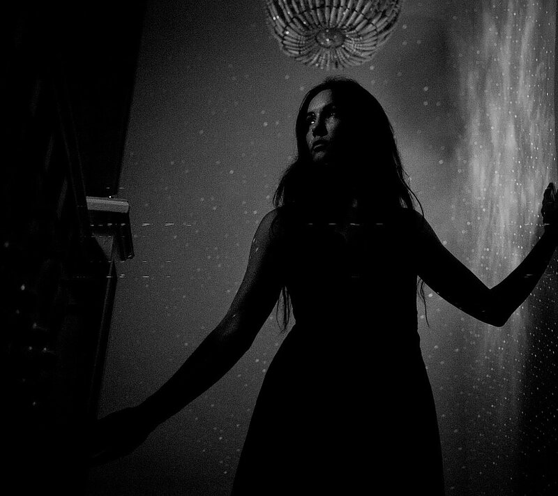 Black and white image of woman in a dark room 