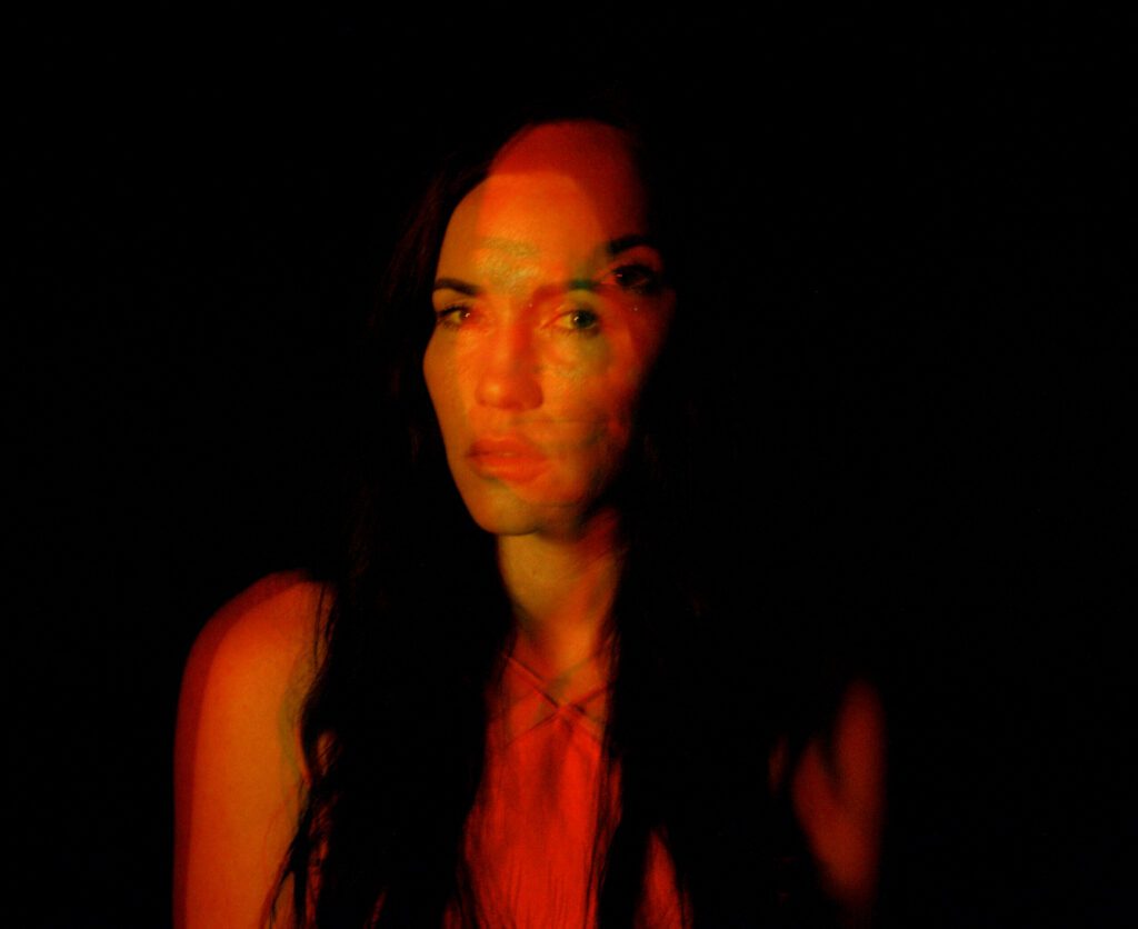 Image of woman in the dark, looking at camera