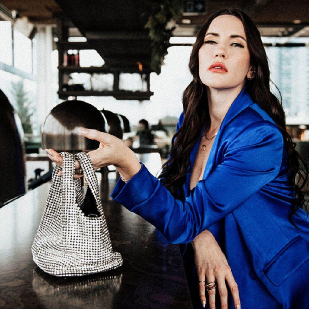 Image of woman holding a shiny handbag.